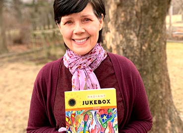 Rebecca Ventura holding her book Radiant Jukebox book